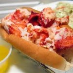 A lobster roll in a bun is served with melted butter and a side of coleslaw at James Place Inn News.