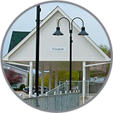 White pavilion with a "Freeport" sign, near black street lamps, under cloudy skies—close to Freeport Maine Inns.