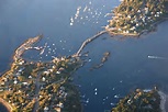 Aerial view of a coastal area with small islands, homes, docks, boats—all classic Maine destinations.