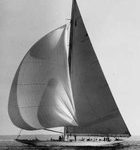A large sailboat with multiple sails glides on calm water—one of the best day trips and activities in Freeport, Maine.