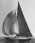 A large sailboat with multiple sails glides on calm water—one of the best day trips and activities in Freeport, Maine.